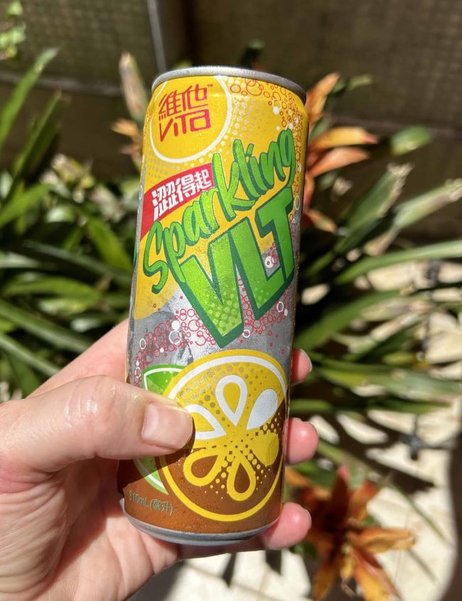 A hand holding a can of sparkling vita lemon tea.