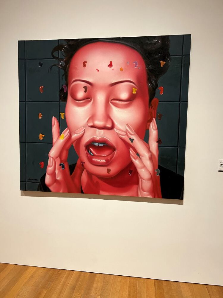 A red painting of a woman with her eyes closed.