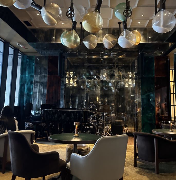 Moody, luxurious lounge interior at DarkSide Bar in Rosewood Hong Kong, featuring eclectic lighting, a jazz stage setup, and plush seating—an atmospheric gem among hidden bars in Hong Kong.