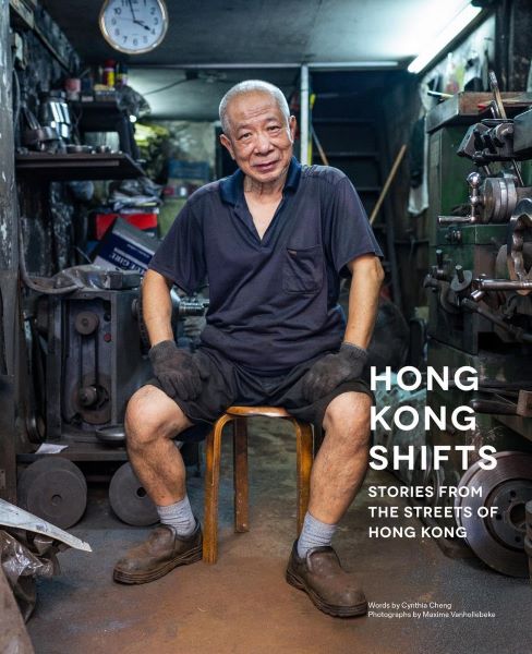 Cover of Hong Kong Shifts: Stories from the Streets of Hong Kong, featuring an older man in work clothes seated in a cluttered workshop, surrounded by industrial tools and machinery. A powerful visual anthology and standout in Hong Kong books, capturing personal stories of the city’s everyday workers through portraits and interviews.